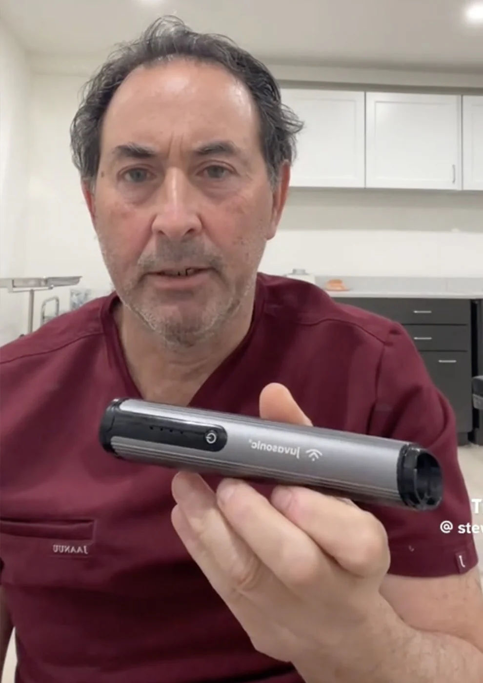 A doctor holding a juvasonic device