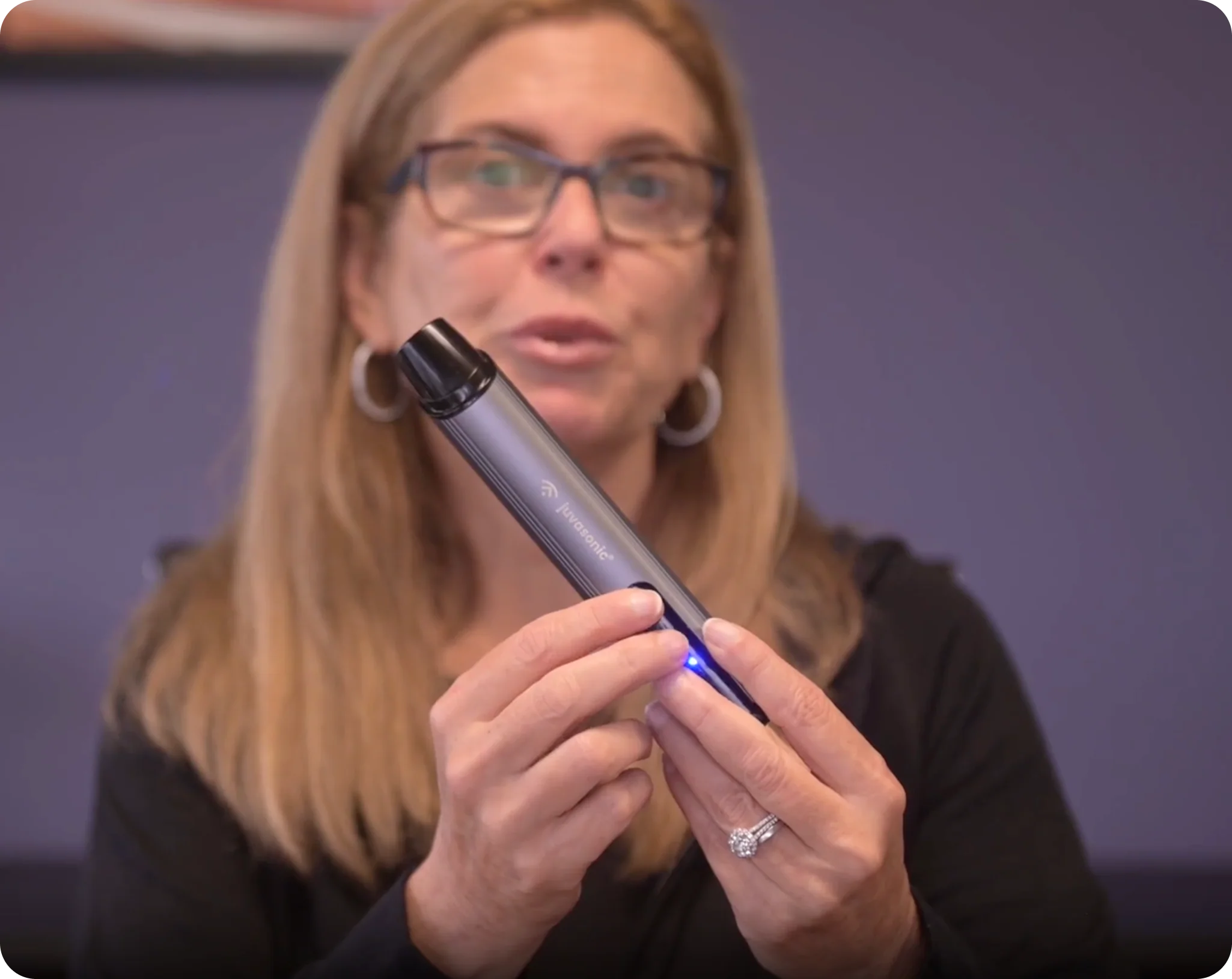 A cosmetic doctor holding and demonstrating the Juvasonic device